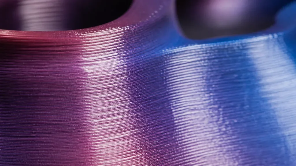 Macro of a silk PLA surface showing the glossy, metallic-like sheen on the printed layers.