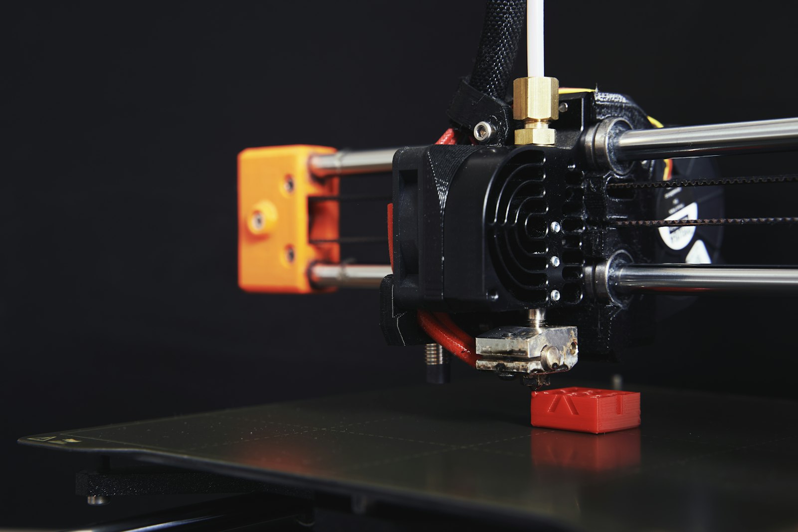 3D printer nozzle and build plate close-up illustrating first layer adhesion problems