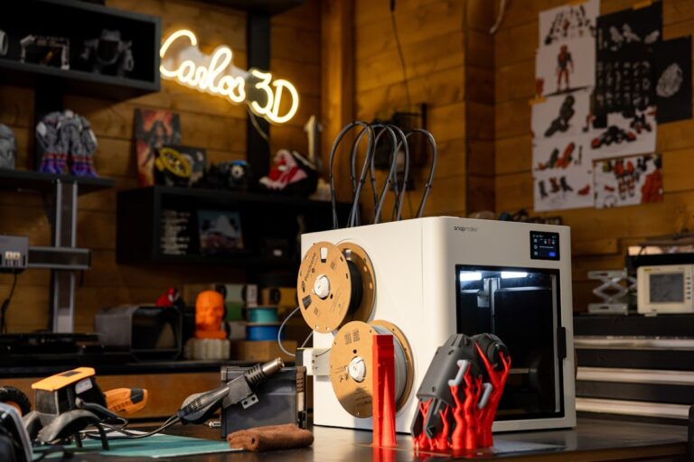 Best budget filament for Bambu Lab — third-party spools and printed parts next to a desktop 3D printer