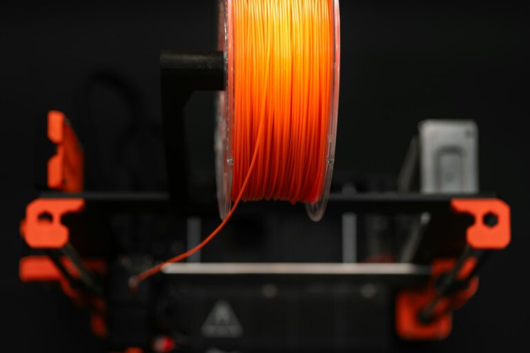 Orange PLA filament spool mounted on a 3D printer